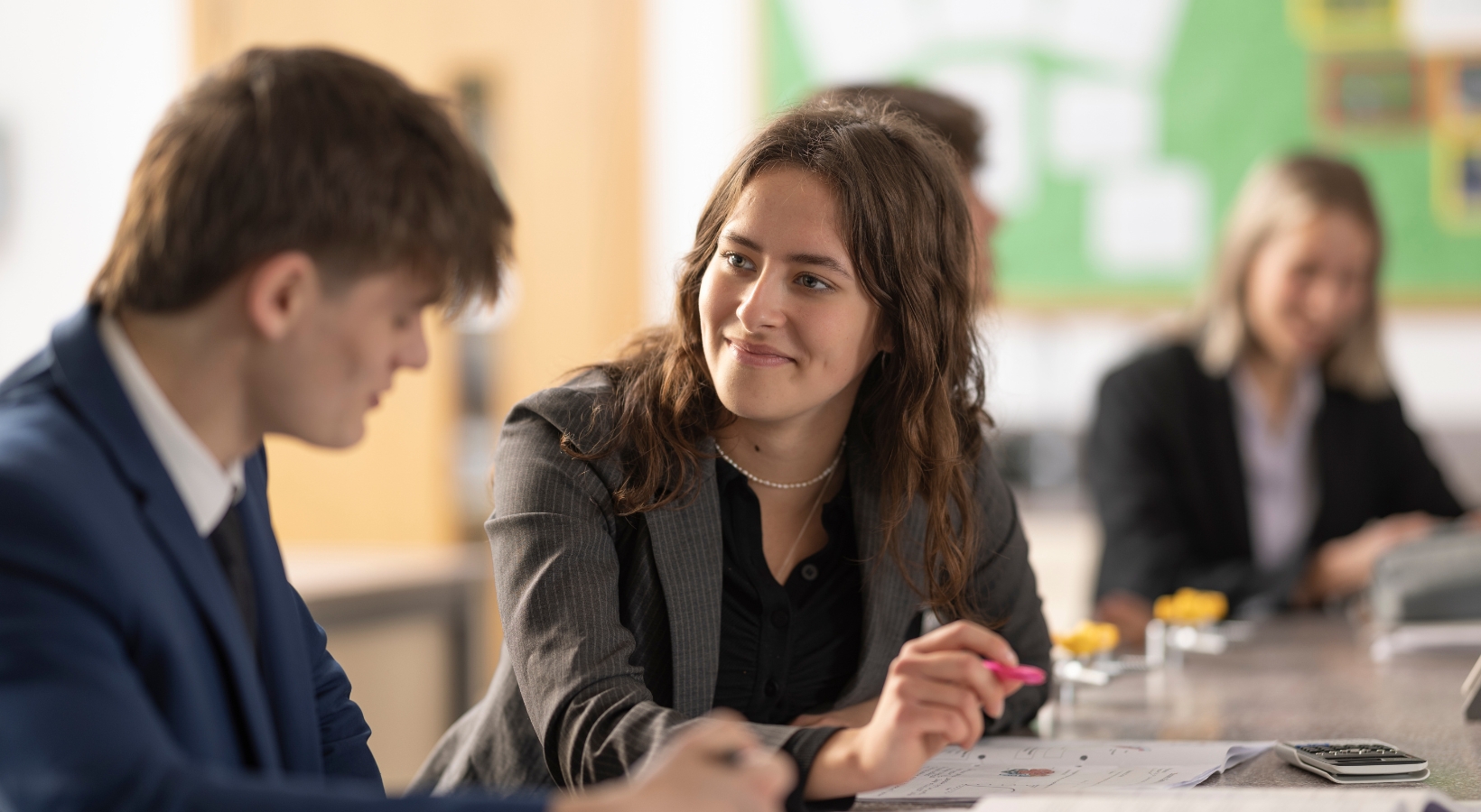 Senior pupils helping each other in their class.