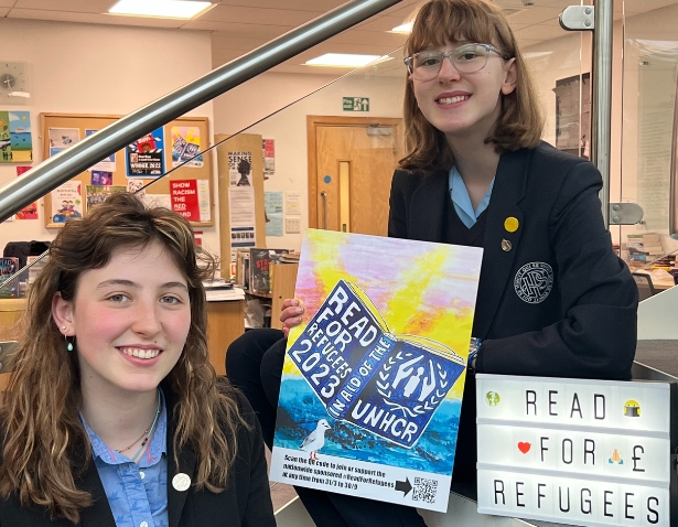 Senior pupils holding books at the library of Ibstock Place School.