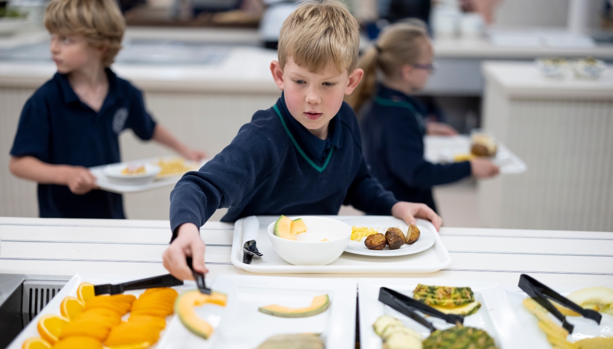 pre-prep pupil taking fruit on his plate at The great hall