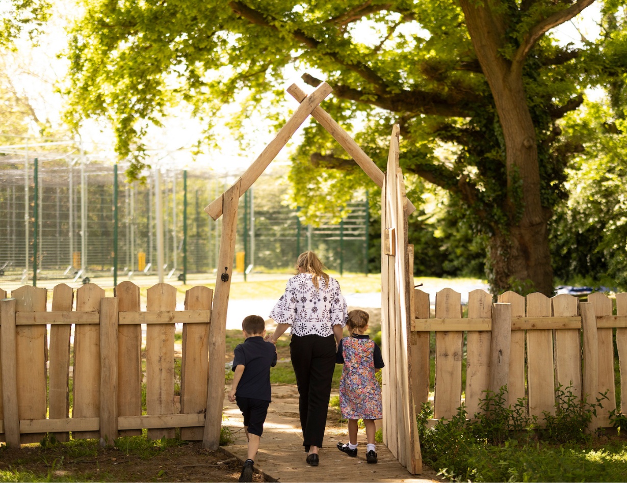 prep pupils holding hands of the teacher at the forest school of Ibstock Place School, a private school near RichmondP