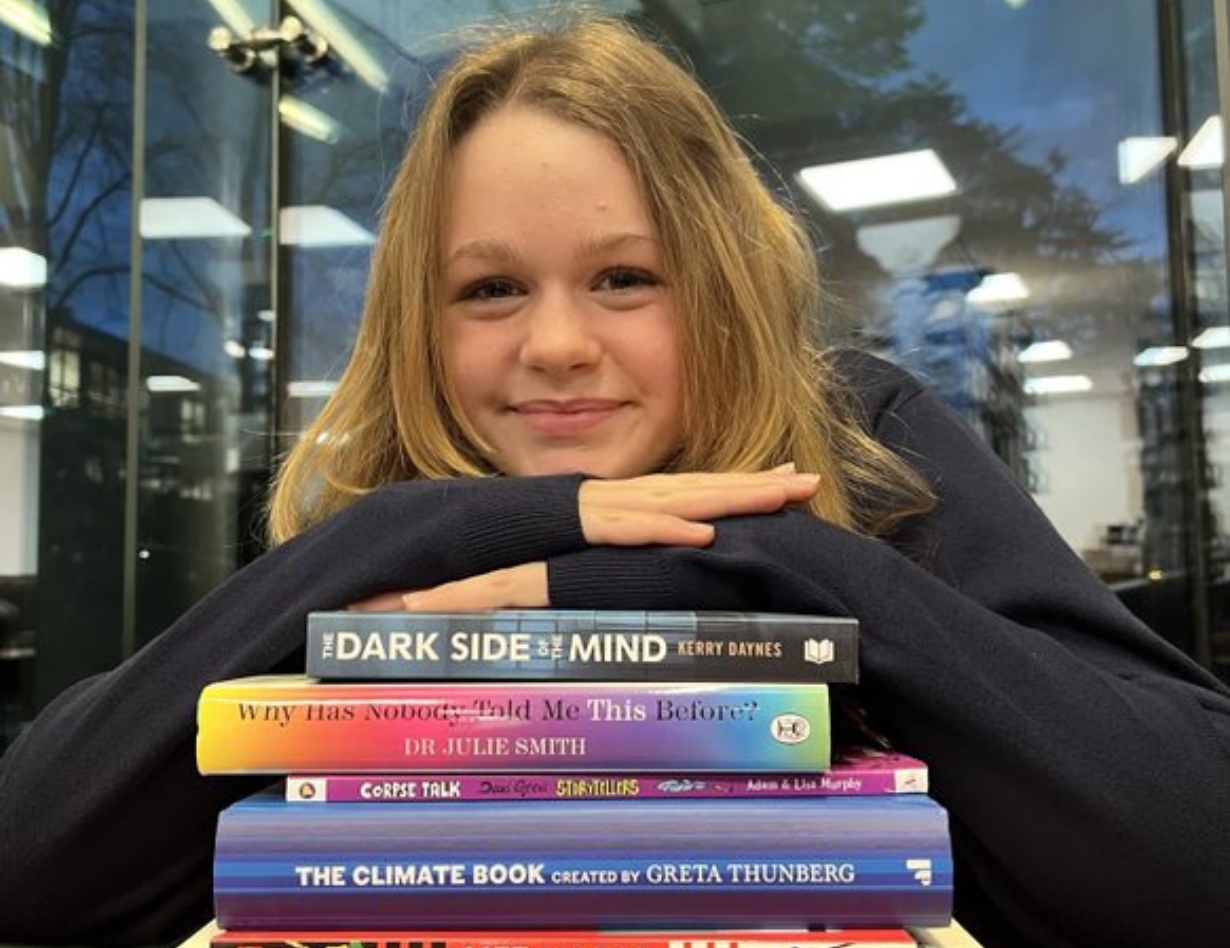 Senior 8 pupils with a stack of books at Ibstock Place School, a private school near Richmond, Barnes, Putney, Kingston, and Wandsworth