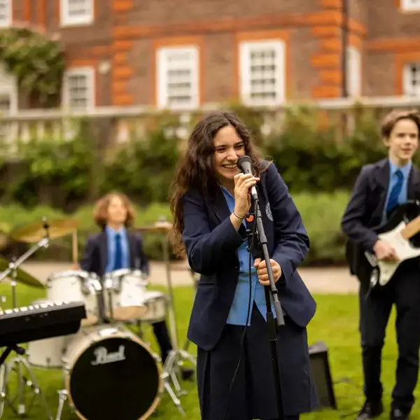 Senior pupil band playing their instruments and singing on the ground of Ibstock Place School.